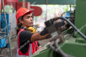 stock photo asian male engineer in red safety vest and helmet checking and repairing old cnc machinery at 2123903426
