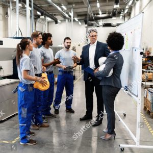 stock photo company manager talking with group of industrial workers while having staff meeting in a factory 1408546379 1