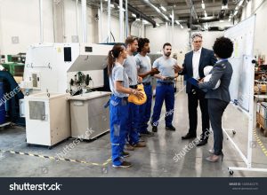 stock photo company manager talking with group of industrial workers while having staff meeting in a factory 1408546379