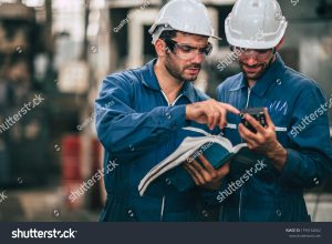stock photo engineer service team looking at machine service manual text book working together as teamwork in 1799162062