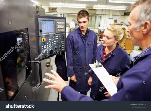 stock photo engineer teaching apprentices to use computerized lathe 165333119
