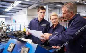 stock photo engineer teaching apprentices to use tube bending machine 165341906 1