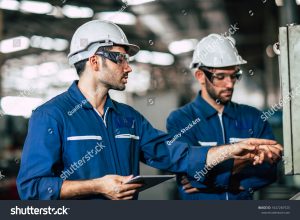 stock photo engineer teamwork checking control panel and teaching new worker to operating control the machine 1647269725