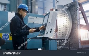 stock photo factory worker is programming a cnc milling machine with a tablet computer 702099130