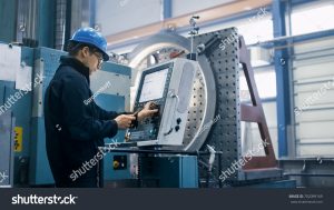 stock photo factory worker is programming a cnc milling machine with a tablet computer 702099169