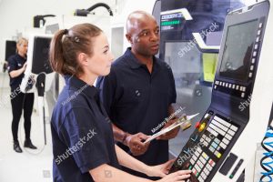 stock photo female apprentice working with engineer on cnc machinery 305421266