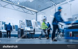 stock photo indusry factory blurred motion shot of a team of engineers professionals and workers working 1902078319