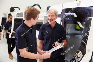 stock photo male apprentice working with engineer on cnc machinery 305421290