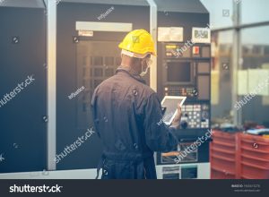 stock photo the engineer control machine in factory by ipad 1945615276