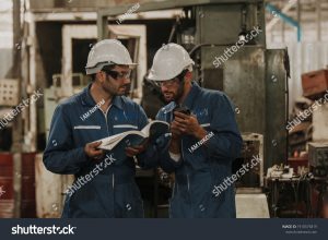 stock photo workers talking and laughing at a factory workers at an industrial plant 1910575819