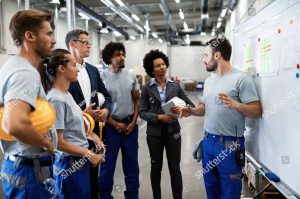 stock photo young factory worker holding presentation about production development to company managers and his 1408546418 1