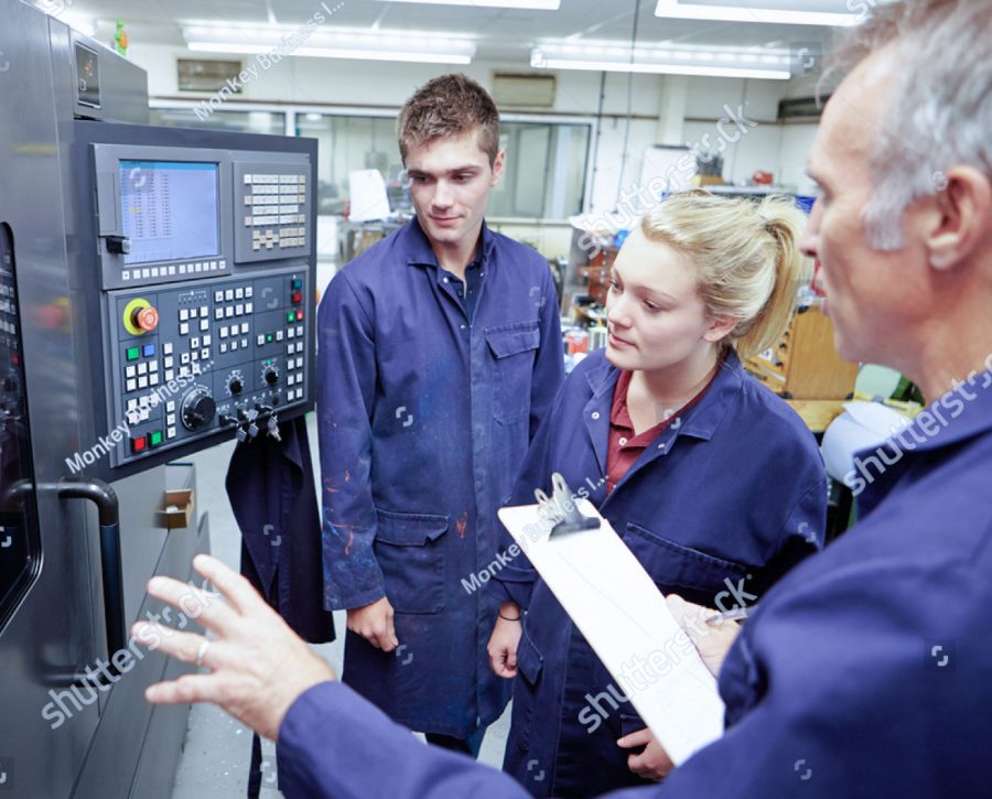 stock photo engineer teaching apprentices to use computerized lathe 165333119 1 1