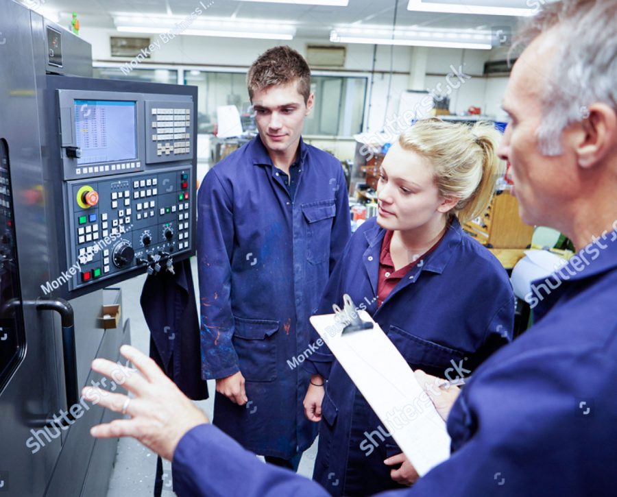 stock photo engineer teaching apprentices to use computerized lathe 165333119 1