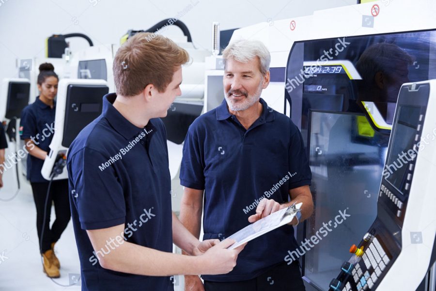 stock photo male apprentice working with engineer on cnc machinery 305421290 3