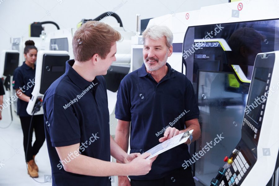 stock photo male apprentice working with engineer on cnc machinery 305421290