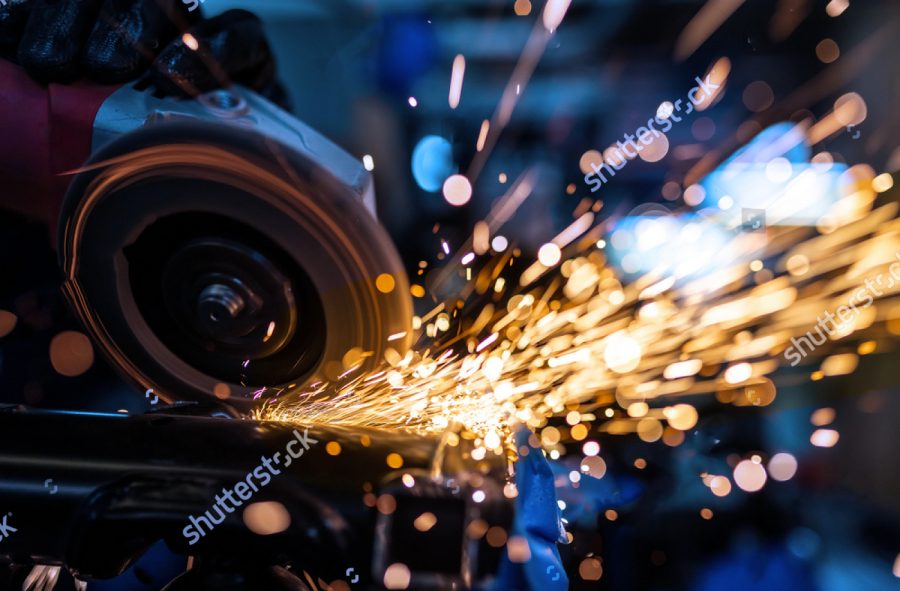 stock photo worker cutting grinding and polishing motorcycle metal part with sparks indoor workshop close up 1458278249 2