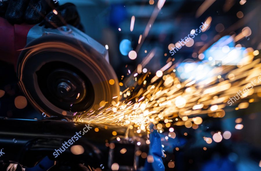 stock photo worker cutting grinding and polishing motorcycle metal part with sparks indoor workshop close up 1458278249 2