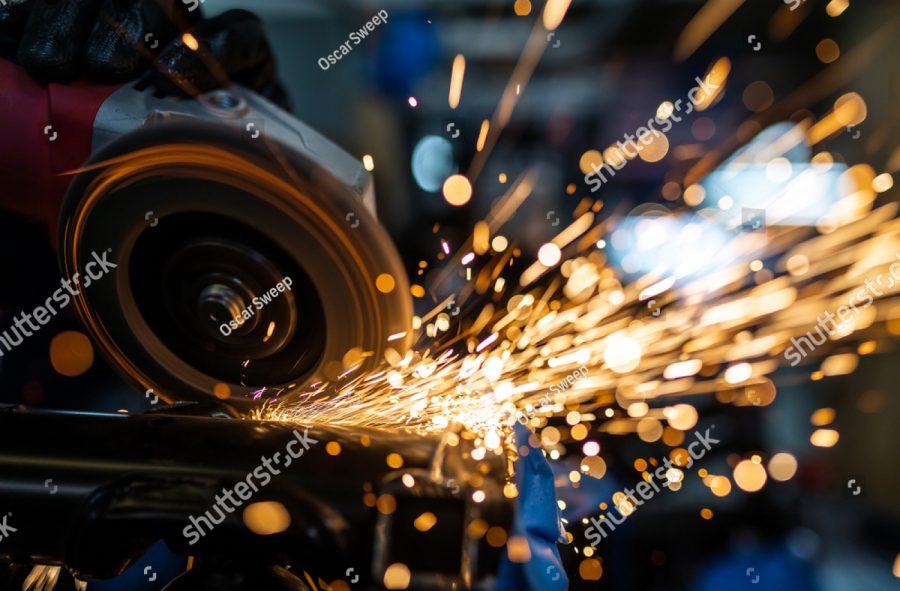 stock photo worker cutting grinding and polishing motorcycle metal part with sparks indoor workshop close up 1458278249
